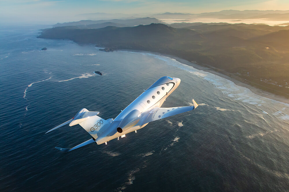 Gulfstream G300 banking over a rugged coastline.